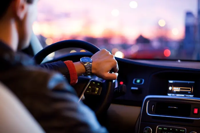 Fahrer am Steuer eines Fahrzeugs in der Abenddämmerung